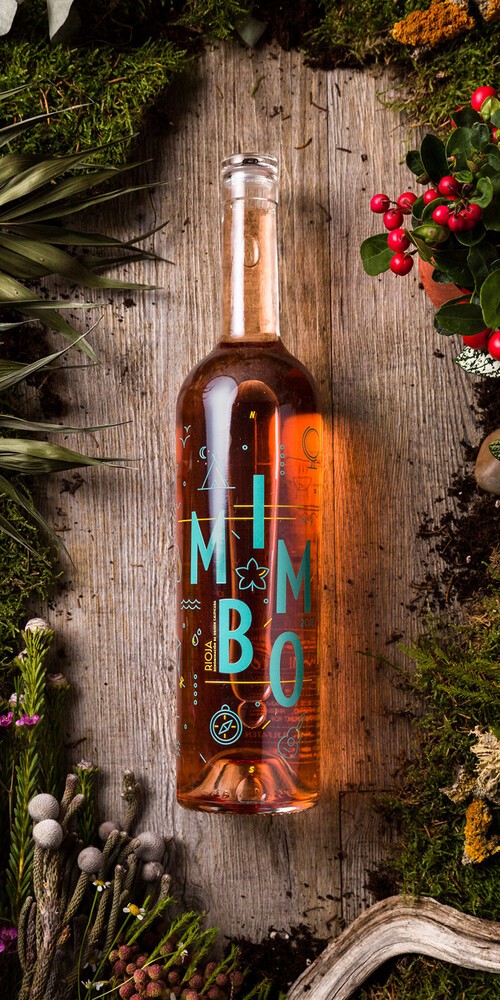 Bodegón con la botella de vino Mimbo rosado, rodeada de vegetación y setas