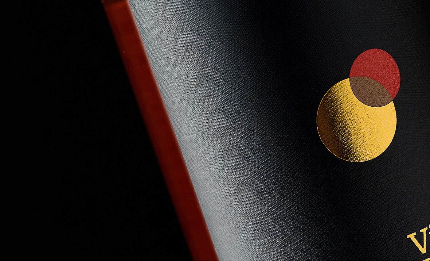 Detalle de etiqueta del vino Viña Dorada, con formas circulares doradas y rojas sugiriendo un eclipse de sol